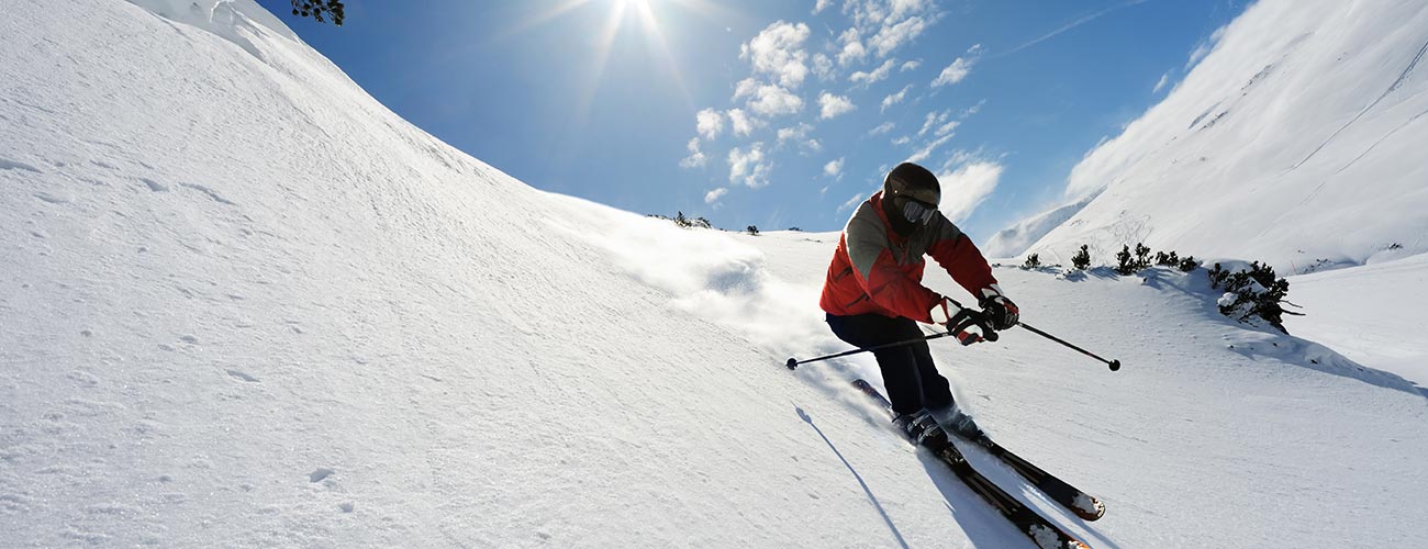Skifahrer im Neuschnee beim Downhill-Fahren