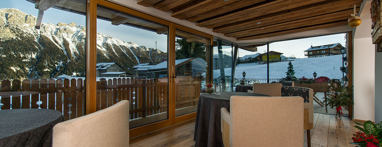 The conservatory of the restaurant Lchimpl overlooking mountains with snow