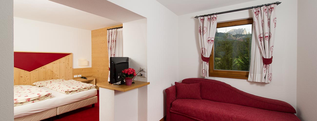 Wohnbereich einer Suite im Hotel Gran Mugon mit Einblick ins Schlafzimmer und dem Doppelbett
