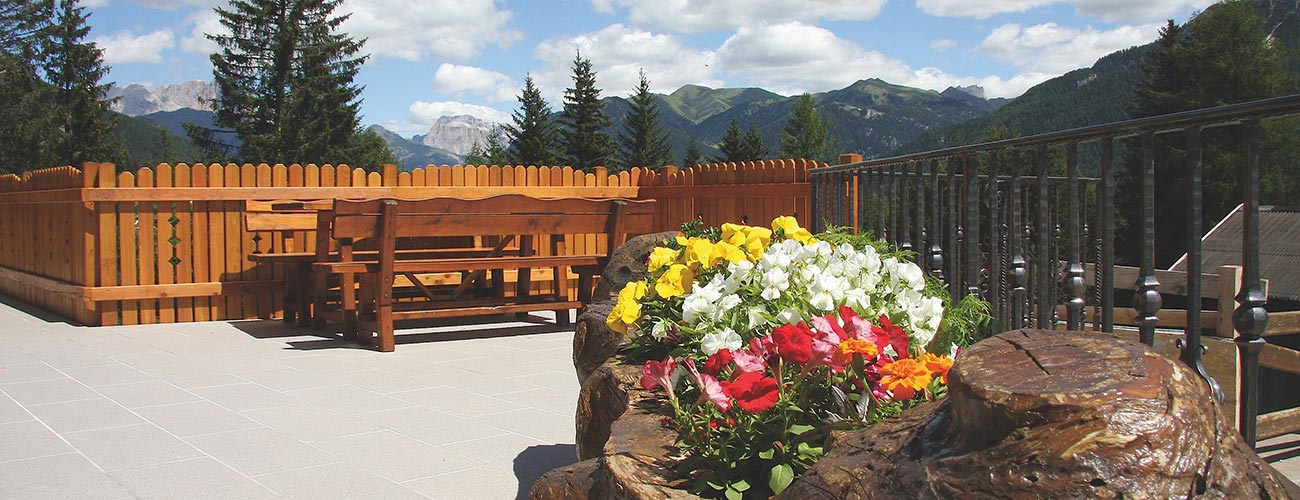 Die Terrasse vom Hotel Gran Mugon mit Bänken und vielen Blumen