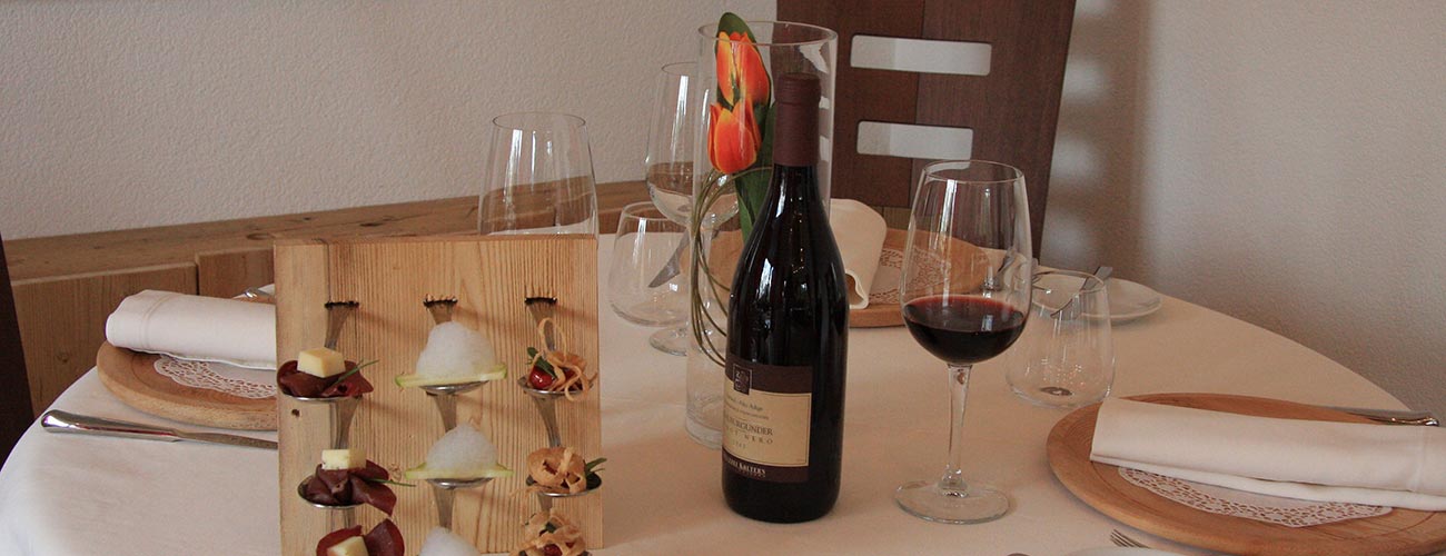 Gedeckter Tisch mit Rotweinflasche und Glas Wein