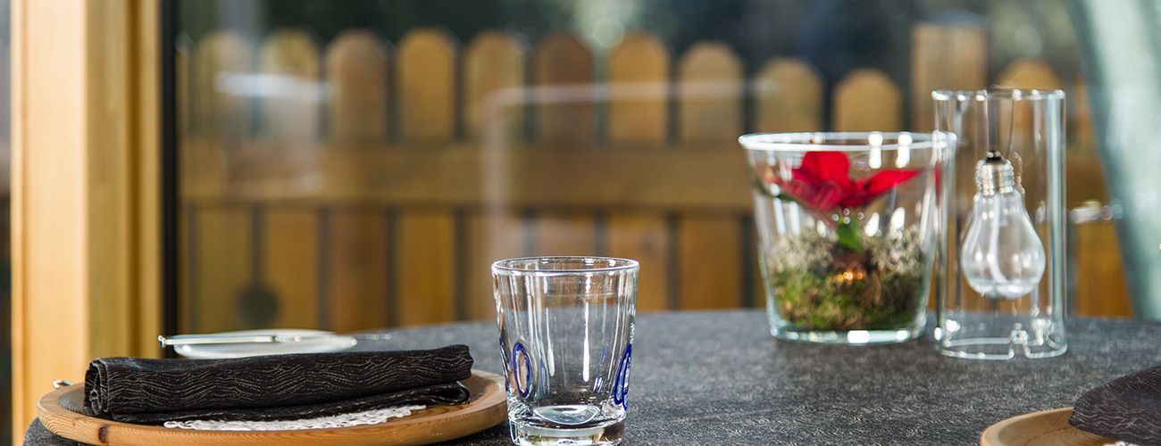 Table with flower decoration, oil candle and a glass