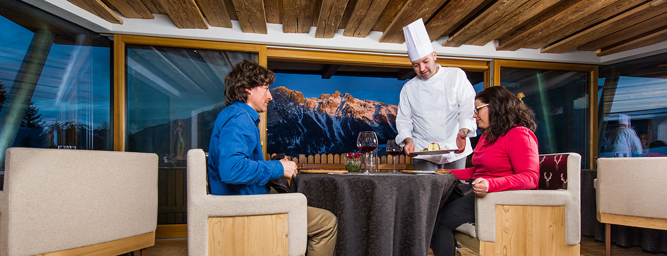 Ein Paar im Michelin-Restaurant Lchimpl vom Hotel Gran Mugon wird von einem Koch am Tisch serviert