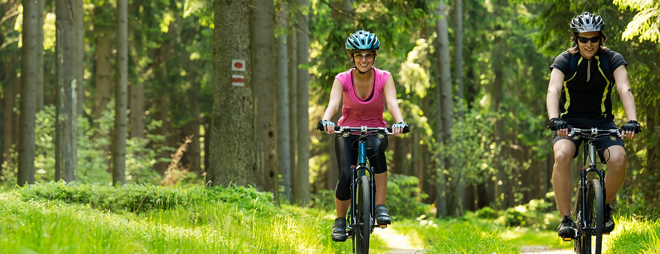 Couple with MTB in the middle of a bike path in the forest